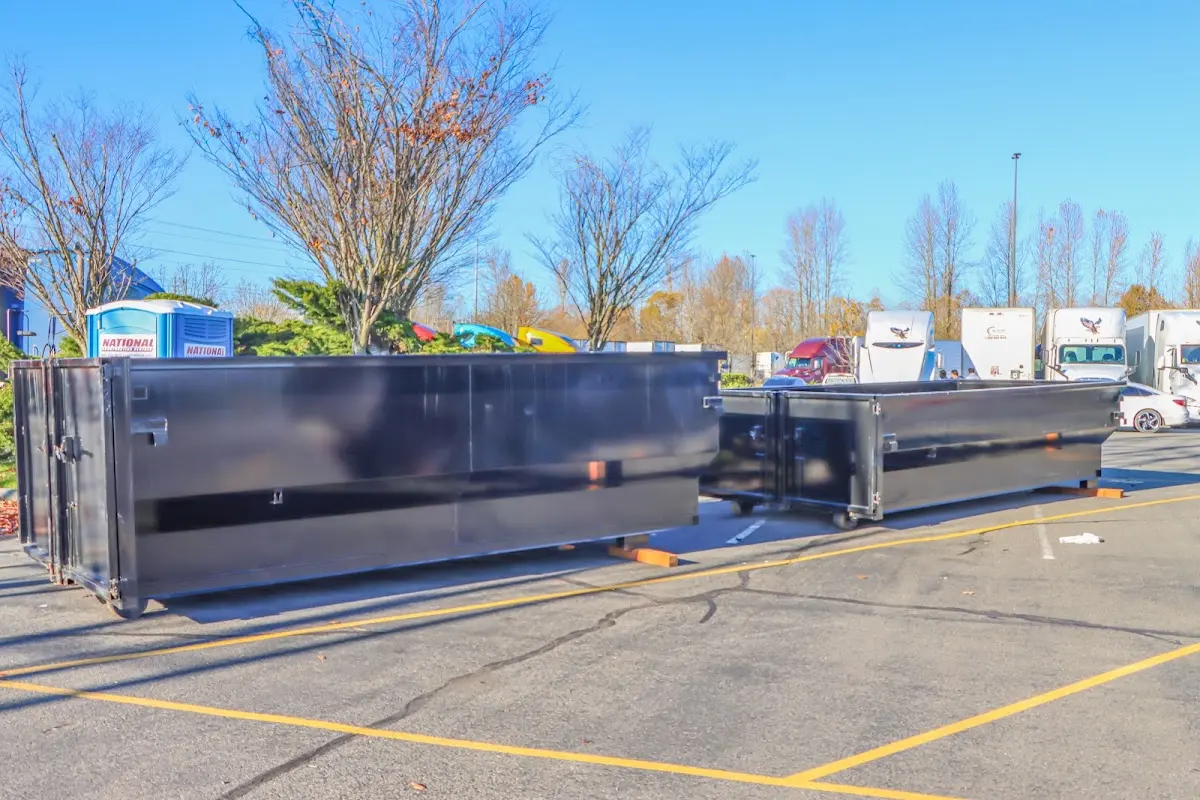 Professional dumpster rental service with roll-off container on residential driveway in Montague